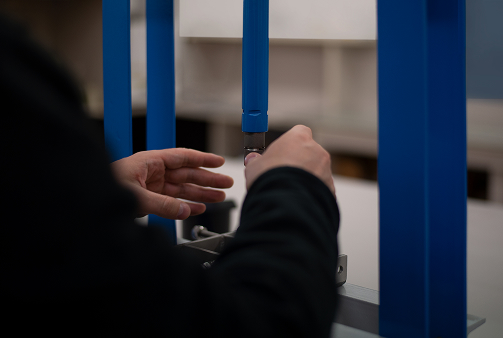 Operatore durante il controllo delle proprietà meccaniche di un campione rivestito