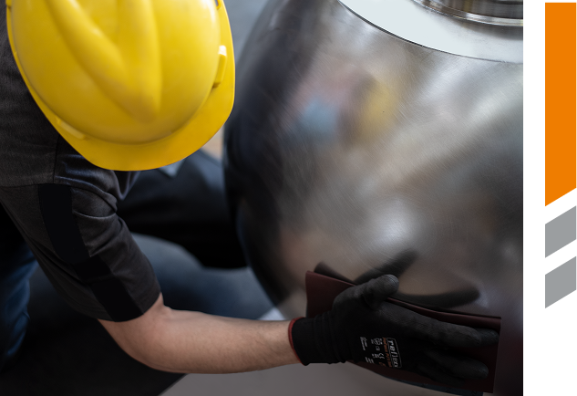 Operatore Deltar durante la finitura manuale di un grande componente metallico